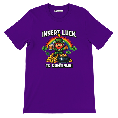 Purple pixel art St. Patrick's Day tee with leprechaun, rainbow, gold coins, shamrocks, and 'Insert Luck To Continue' text.