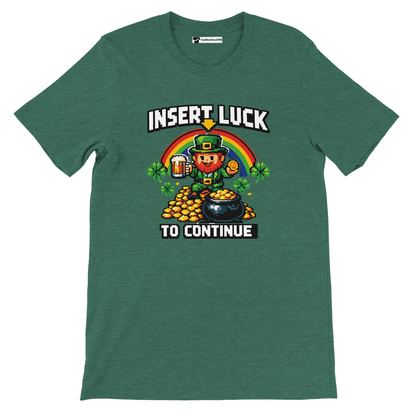 Green pixel art St. Patrick's Day tee with leprechaun, rainbow, gold coins, shamrocks, and 'Insert Luck To Continue' text