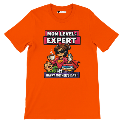 Orange Mother's Day t-shirt with cartoon super mom, baby, toys, and 'Mom Level: Expert' text.