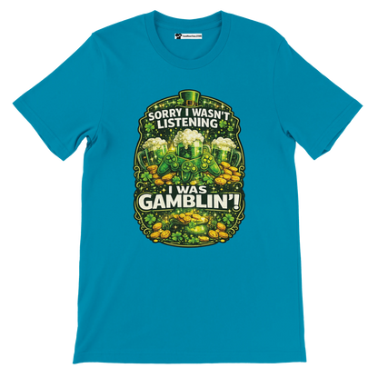 Blue St. Patrick's Day tee with shamrocks, gold coins, beer mugs, and 'Sorry I Wasn't Listening I Was Gamblin'' quote.