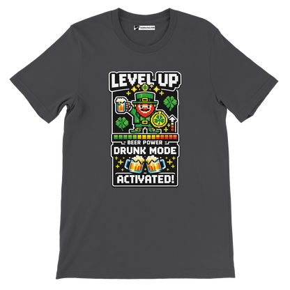 Gray t-shirt with pixel art leprechaun, shamrocks, and 'Level Up Drunk Mode Activated' text for St. Patrick's Day.