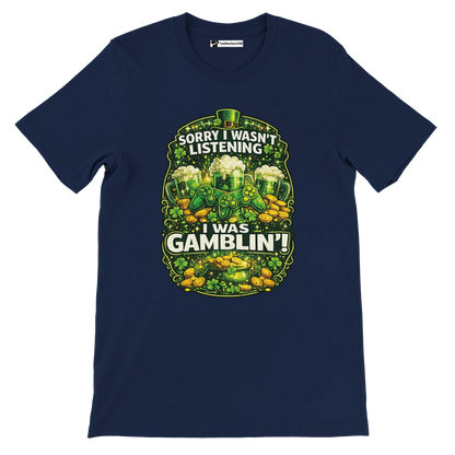 Navy t-shirt with 'Sorry I wasn't listening I was gamblin' text, shamrocks, coins, game controller, and green beer mugs, St. Patrick's Day theme.