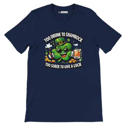 Navy t-shirt with cartoon shamrock wearing sunglasses, holding beer, surrounded by coins, St. Patrick's Day design, text says 'Too Drunk to Shamrock, Too Sober to Give a Luck'.