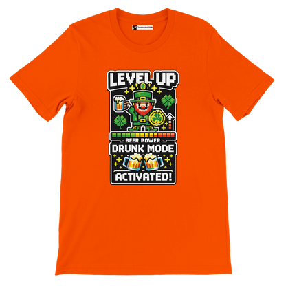 Orange St. Patrick’s Day tee with pixel leprechaun, beer, shamrocks, and 'Level Up Drunk Mode Activated' text