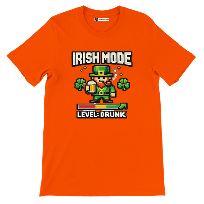 Orange St. Patrick's Day tee with pixel leprechaun, 'Irish Mode Level: Drunk' text, shamrocks, beer graphic