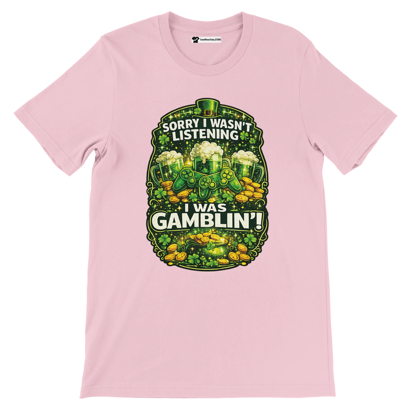 Pink tee with shamrocks, gold coins, green beer, and 'Sorry I wasn't listening, I was gamblin'' quote.