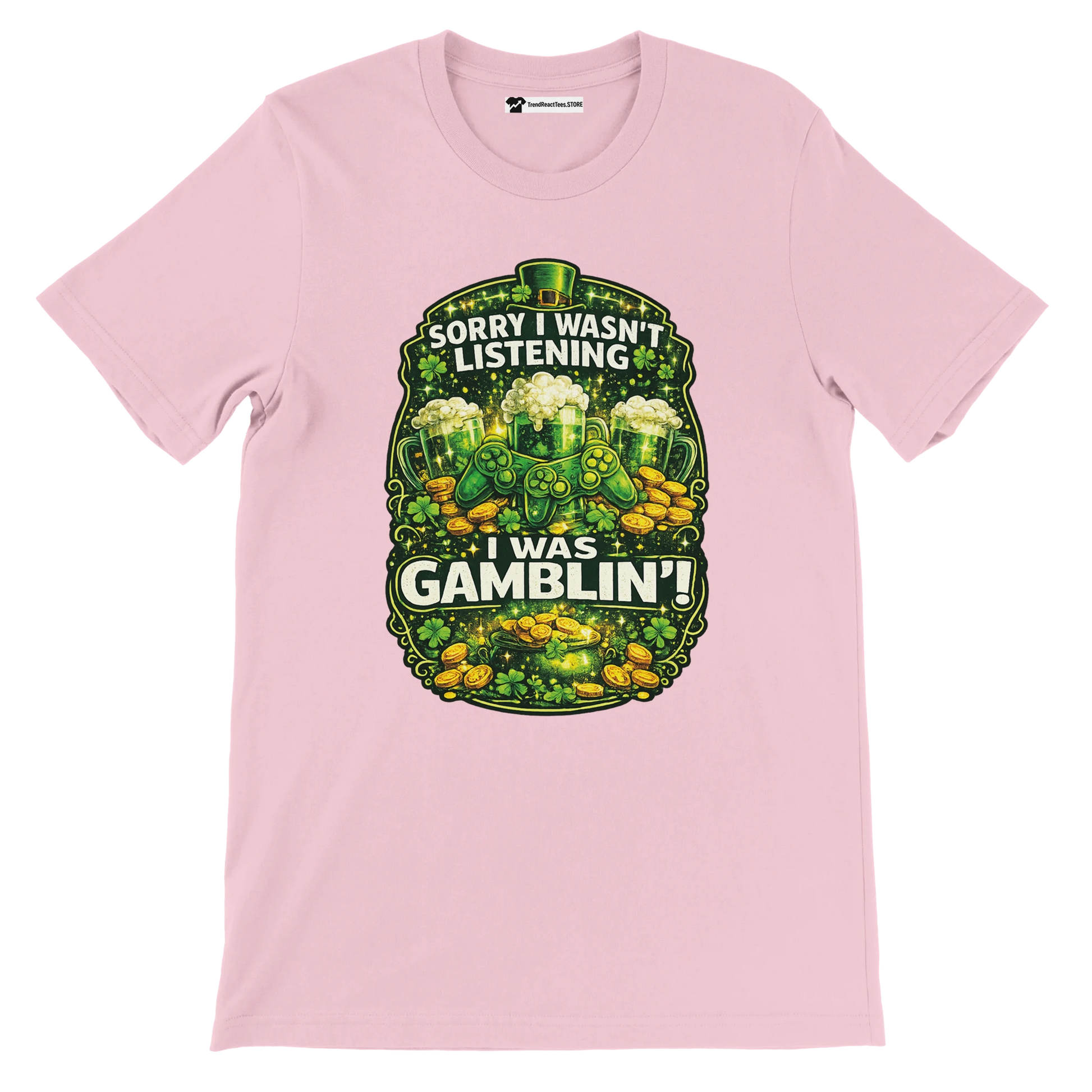 Pink tee with shamrocks, gold coins, green beer, and 'Sorry I wasn't listening, I was gamblin'' quote.