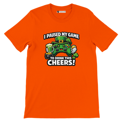 Orange t-shirt with St. Patrick's Day gamer graphic, green controller, text: I paused my game to drink this cheers, clover and beer mug design
